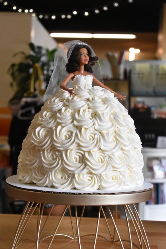 A doll cake with a dress of piped white buttercream roses
