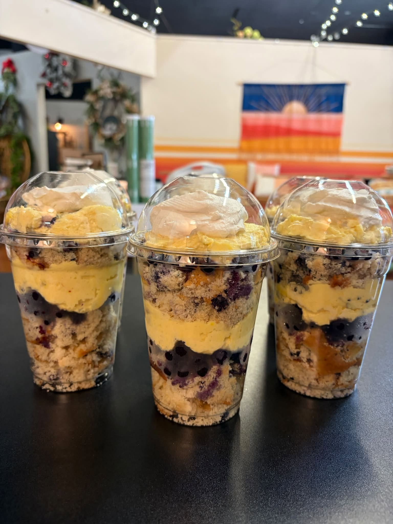 Three dessert cups layered with cake, cream and fruit